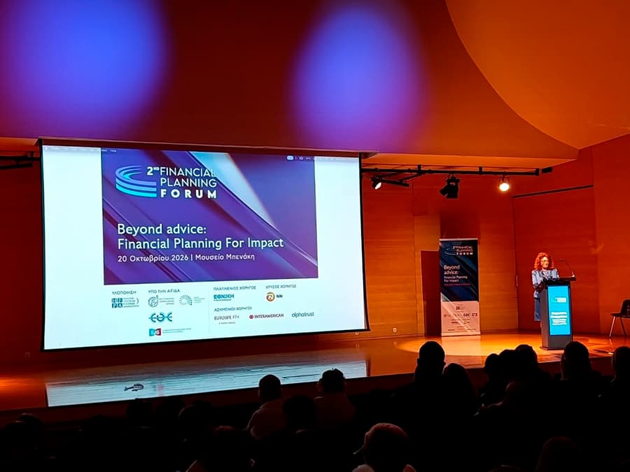 Η Ευφροσύνη Στουργιώτου στο βήμα του 2ου Financial Planning Forum, με την οθόνη του συνεδρίου και το κοινό στο Μουσείο Μπενάκη